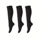 Three black knee-high socks on a white background